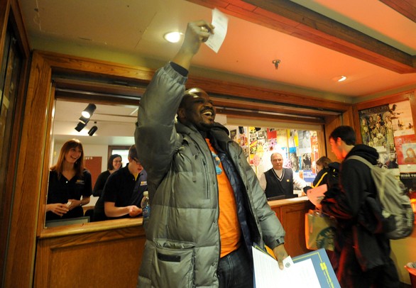 U-M Taubman College of Architecture faculty member Teman Evans holds up his ticket to see President Barack Obama speak while people in line behind him cheer. Evans was the first person in line at 7:30 pm last night. Angela J. Cesere | AnnArbor.com